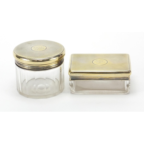 2224 - Asprey, two cut glass jars with silver gilt lids and engine turned decoration, the largest 9cm wide