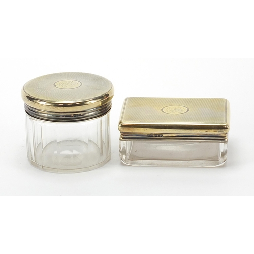 2224 - Asprey, two cut glass jars with silver gilt lids and engine turned decoration, the largest 9cm wide