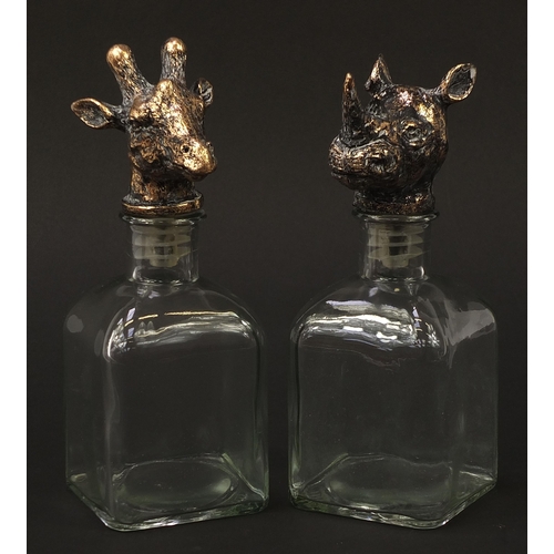 429 - Pair of glass decanters with rhinoceros and giraffe head stoppers, 24cm high
