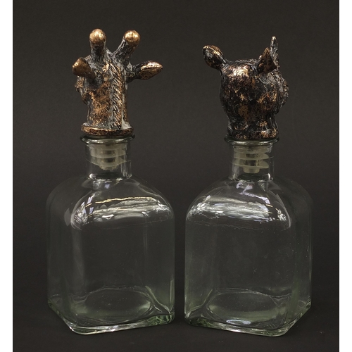 429 - Pair of glass decanters with rhinoceros and giraffe head stoppers, 24cm high