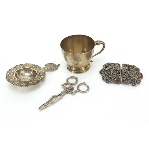 2223 - Sterling silver cup, naturalistic silver straining spoon and a white metal two piece buckle and nove... 