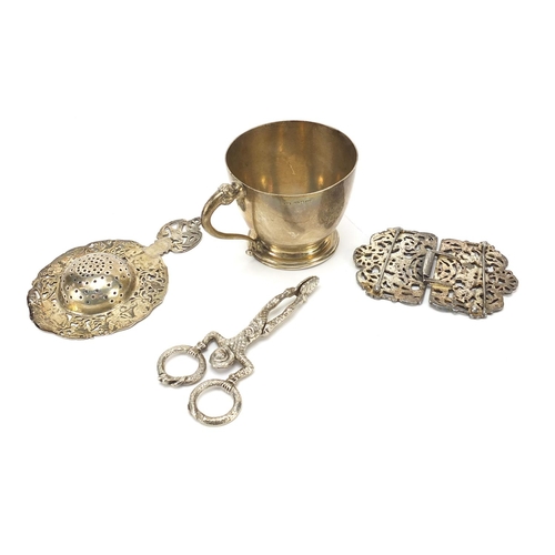 2223 - Sterling silver cup, naturalistic silver straining spoon and a white metal two piece buckle and nove... 