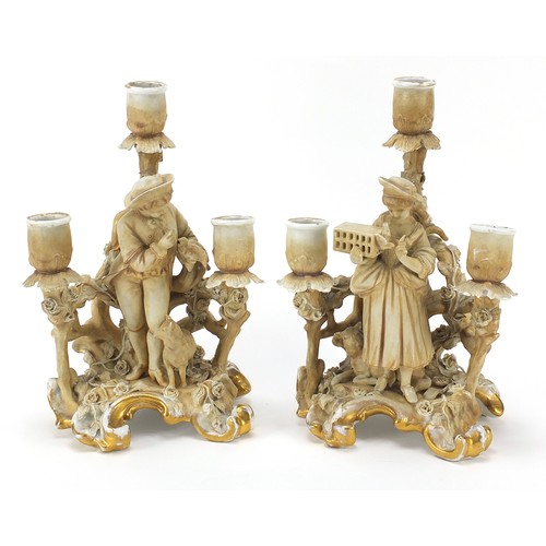 219 - Pair of continental porcelain figural three branch candelabras by Plaue, each 26cm high
