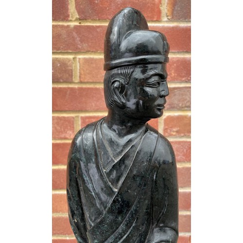 299 - Large Chinese carved green/black stone figure of a standing figure holding a scroll, 69cm high