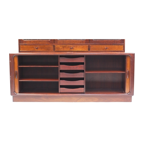 694 - Dyrlund, Danish rosewood wall unit with three glazed doors above two sliding tambour doors, enclosin... 