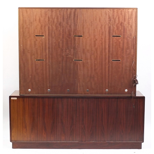 694 - Dyrlund, Danish rosewood wall unit with three glazed doors above two sliding tambour doors, enclosin... 