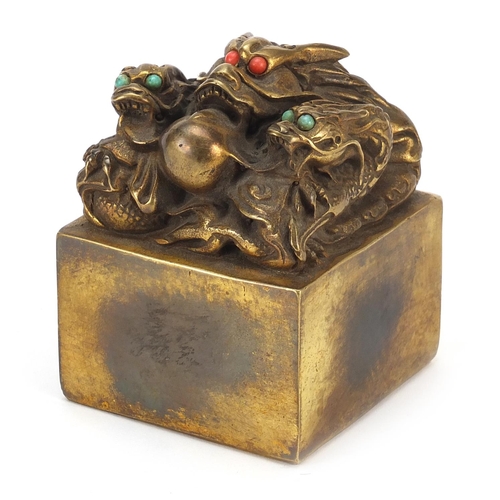 642 - Large Chinese bronze desk seal in the form of three dragons with coral and turquoise coloured eyes, ... 