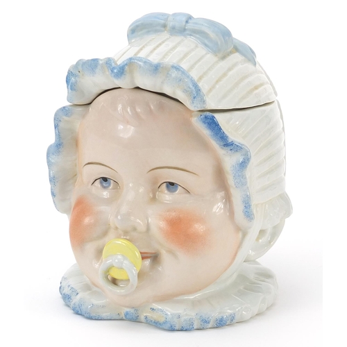 138 - Continental porcelain baby's head tobacco jar and cover, 13cm high