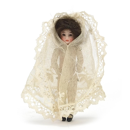 1943 - 19th century miniature bisque doll wearing a white lace dress, 10cm high