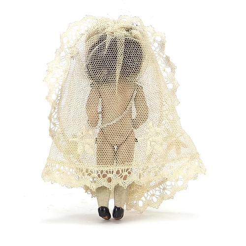 1943 - 19th century miniature bisque doll wearing a white lace dress, 10cm high