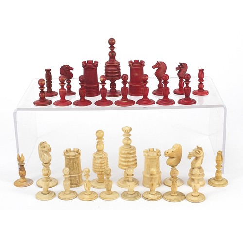 1959 - Half stained carved bone chess pieces, housed in an antique oak box, the largest piece 8.5cm high