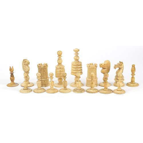 1959 - Half stained carved bone chess pieces, housed in an antique oak box, the largest piece 8.5cm high