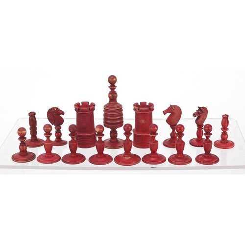 1959 - Half stained carved bone chess pieces, housed in an antique oak box, the largest piece 8.5cm high