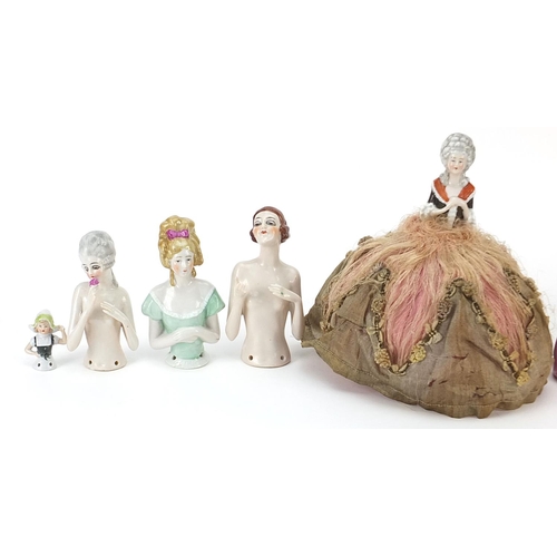 318 - Eight continental porcelain half pin dolls and a crinoline lady pot and cover, the largest 18cm high