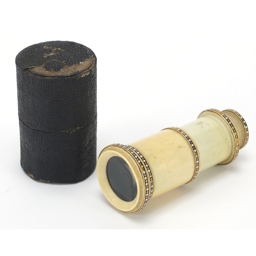 423 - Georgian ivory monocular with enamelled unmarked gold mounts and case, 6.5cm in length when closed