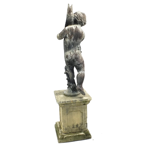 688a - Lead garden water feature of Putti holding a fish, raised on a square concrete base, 145cm high