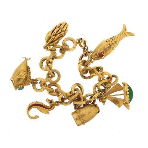 23 - 18ct gold charm bracelet with a selection of gold charms including enamelled seahorse, drum with mot... 