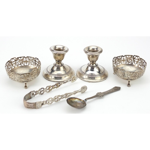 58 - Silver objects comprising pair of dwarf candlesticks, pair of open salts, sugar tongs and a spoon, v... 