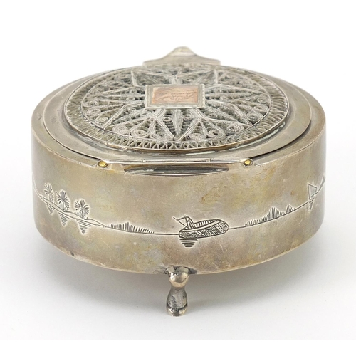 59 - Circular unmarked silver jewel box with hinged filigree lid and mirrored interior raised on three fe... 