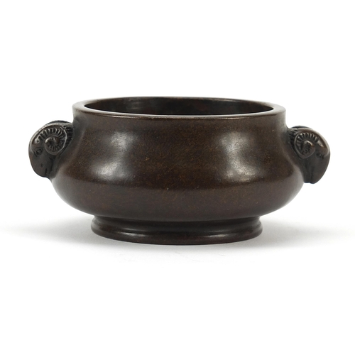 1304 - Chinese patinated bronze censer with ram's head handles, character marks to the base, 11cm wide