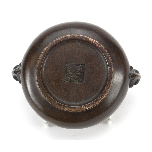 1304 - Chinese patinated bronze censer with ram's head handles, character marks to the base, 11cm wide