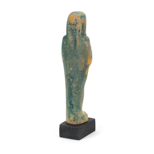 1264 - Egyptian style ushabti raised on a wooden base, overall 18cm high