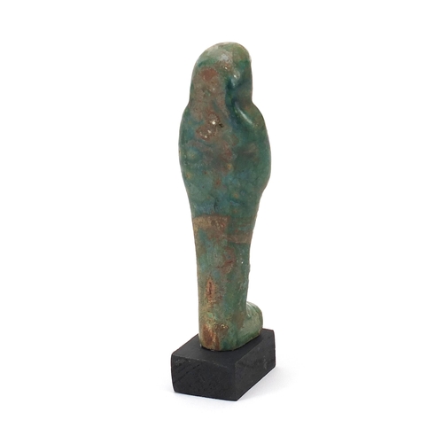 1265 - Egyptian style ushabti raised on a wooden base, overall 16.5cm high