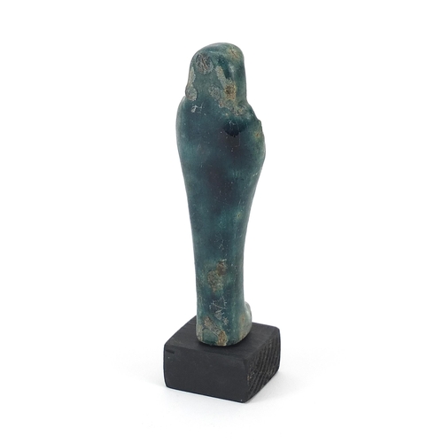 1266 - Egyptian style ushabti raised on a wooden base, overall  13cm high