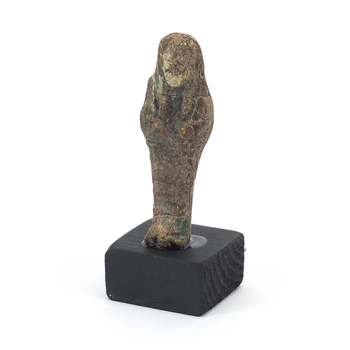 1526 - Egyptian style ushabti raised on a wooden base, overall 9cm high