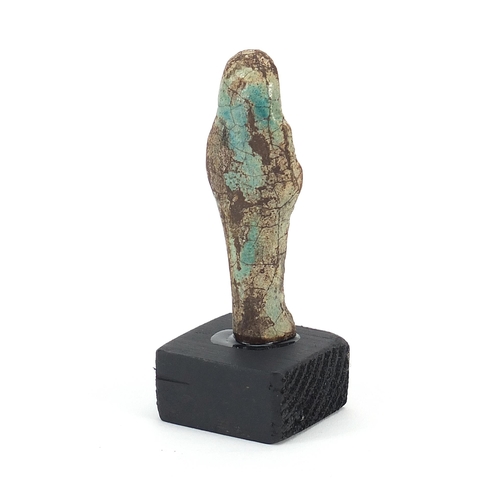 1526 - Egyptian style ushabti raised on a wooden base, overall 9cm high