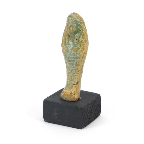 1524 - Egyptian style ushabti raised on a wooden base, overall 8.5cm high