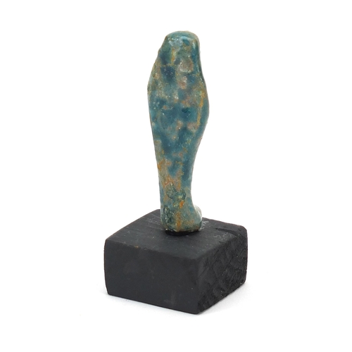 1525 - Egyptian style ushabti raised on a wooden base, overall 8cm high