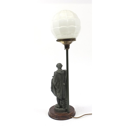 184 - Patinated spelter Shakespeare design table lamp with globular glass shade raised on a circular oak p... 