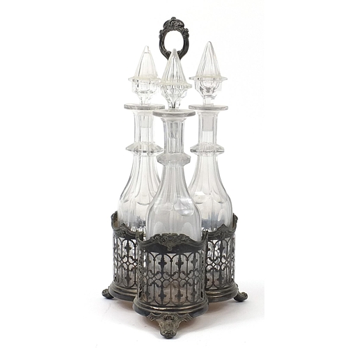 1236 - Three cut glass decanters housed in a silver plated tantalus, 42cm high