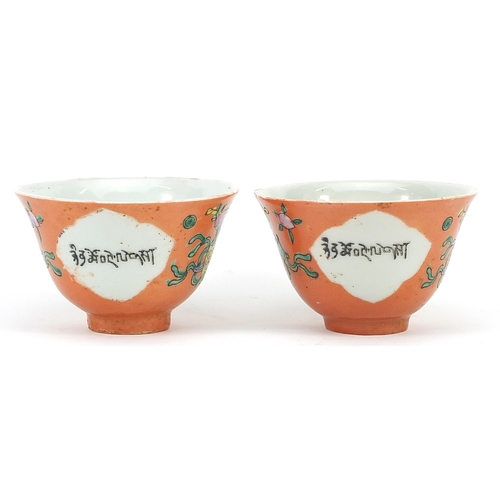 535 - Pair of Chinese Islamic peach ground porcelain bowls hand painted with Daoist emblems and calligraph... 