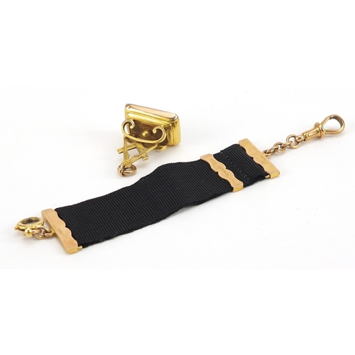 822 - 9ct gold and black onyx masonic fob with gold mounted ribbon, 16.5cm in length, 13.0g