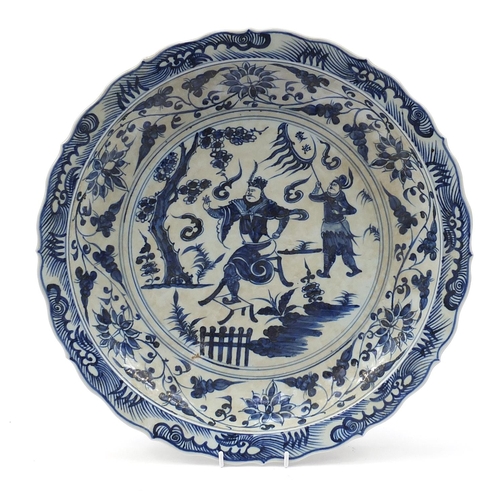 1756 - Large Chinese blue and white porcelain charger hand painted with warriors amongst foliage, character... 