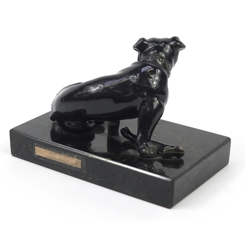 371 - Patinated spelter dog with bone raised on a rectangular black slate base, 13cm wide