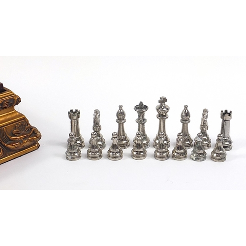 1744 - Ornate gilt framed chess board with metal pieces, the largest pieces each 7cm high