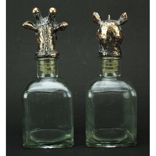 519 - Pair of glass decanters with bronzed rhinoceros and giraffe head stoppers, 24cm high