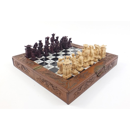 734 - Chinese carved wood figural chess set with folding board, 47cm wide