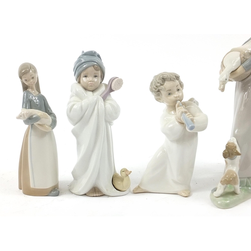 502 - Five Lladro figures including a girl picking flowers and a young girl in a bath robe, the largest 27... 