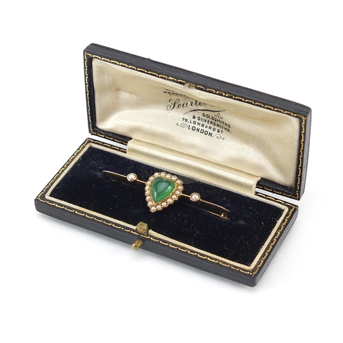 763 - Unmarked gold green stone and seed pearl love heart bar brooch housed in a Searle & Co Ltd London fi... 