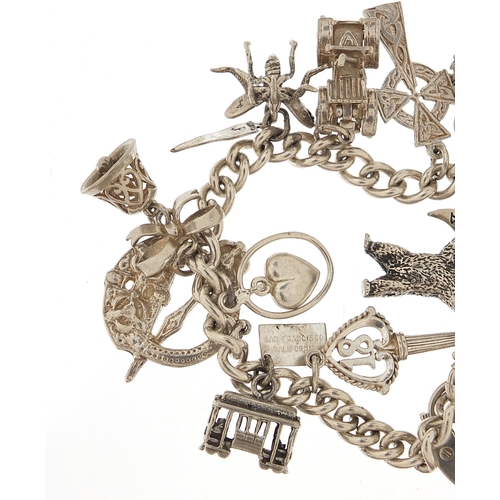 1072 - Silver charm bracelet with a selection of mostly silver charms, 16cm in length, 54.5g