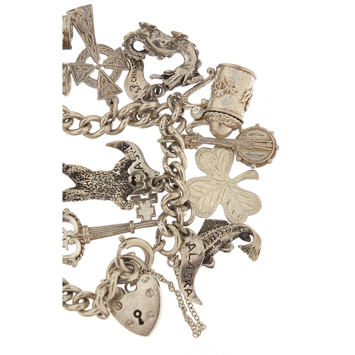 1072 - Silver charm bracelet with a selection of mostly silver charms, 16cm in length, 54.5g