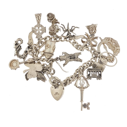 1072 - Silver charm bracelet with a selection of mostly silver charms, 16cm in length, 54.5g