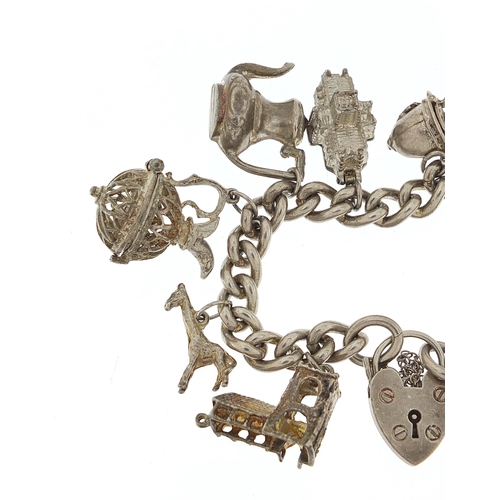 1087 - Silver charm bracelet with a selection of mostly silver charms, 72.6g