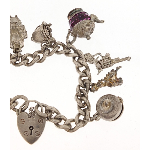 1087 - Silver charm bracelet with a selection of mostly silver charms, 72.6g