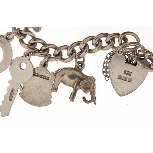 1066 - Silver charm bracelet with a selection of mostly silver charms, 56.8g