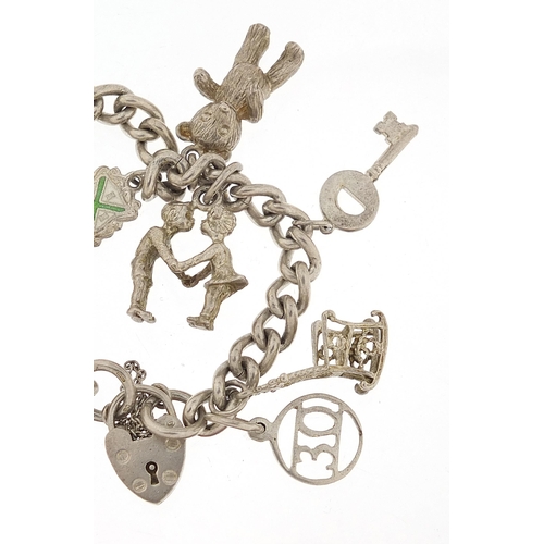 1044 - Silver charm bracelet with a selection of mostly silver charms, 56.8g